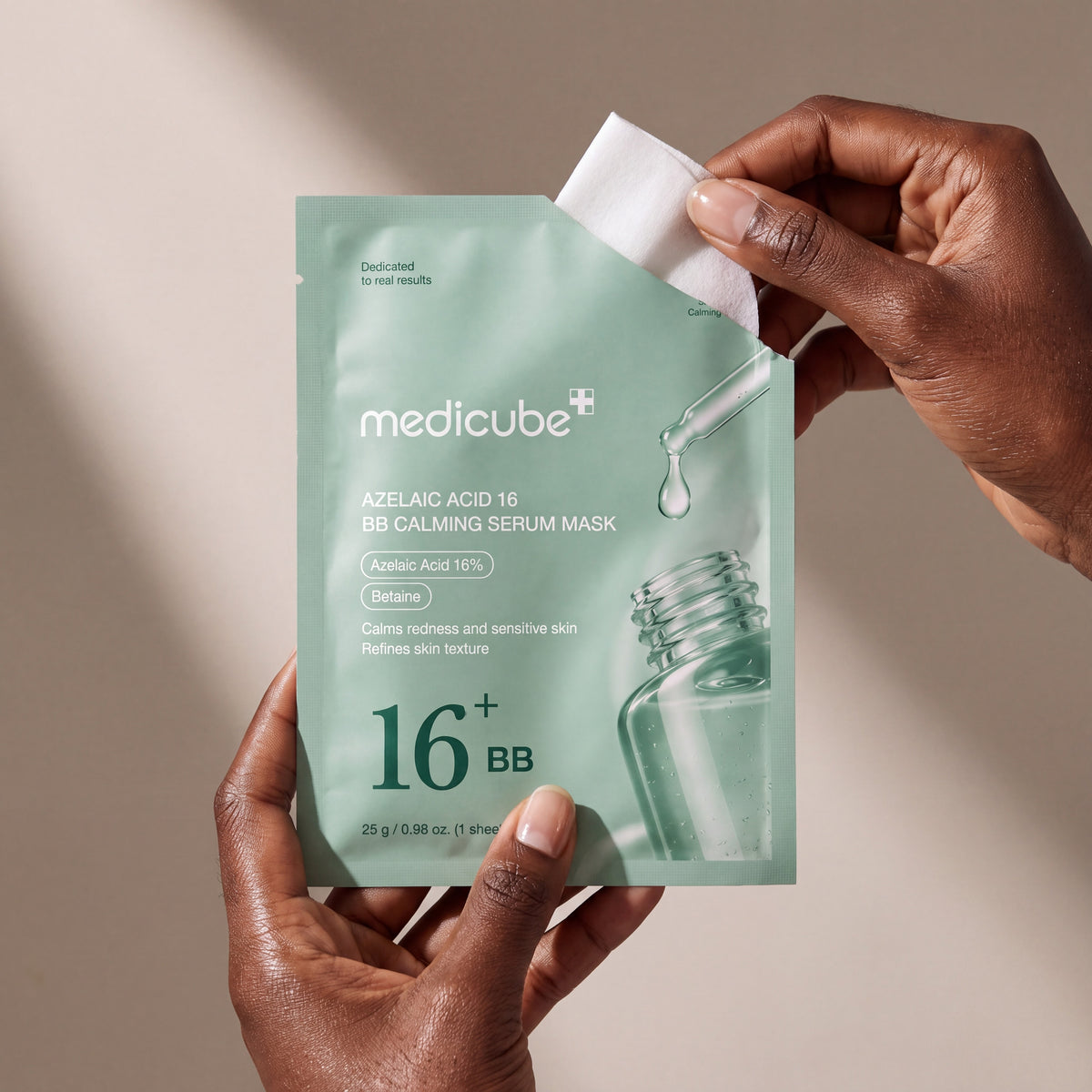 Medicube Azelaic Acid 16 BB Calming Serum Mask held in hands, editorial studio shot