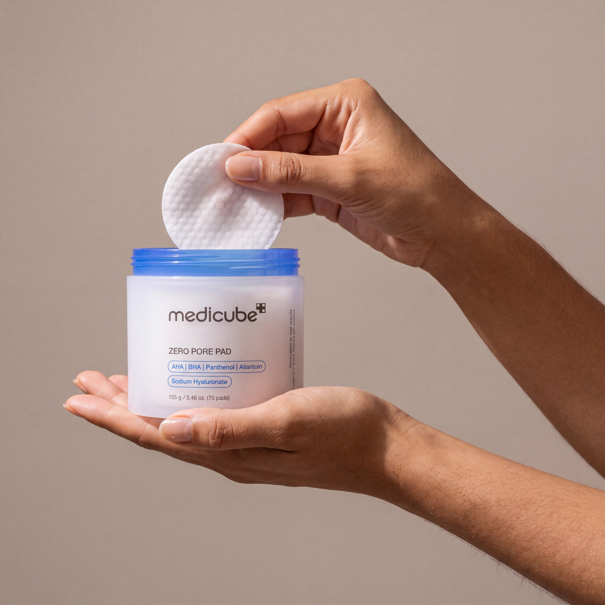 Medicube Zero Pore Pad 2.0 held in hands, editorial studio shot