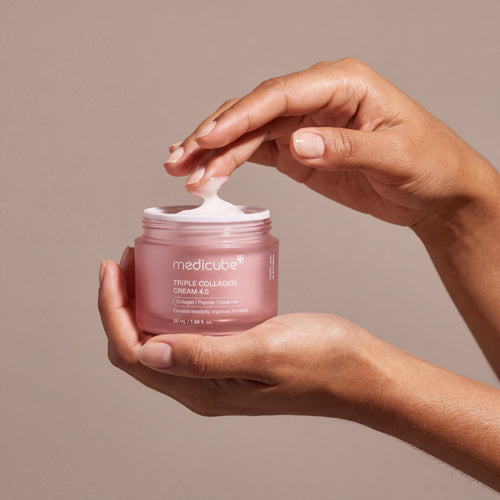 Medicube Triple Collagen Cream 4.0 held in hands, editorial studio shot