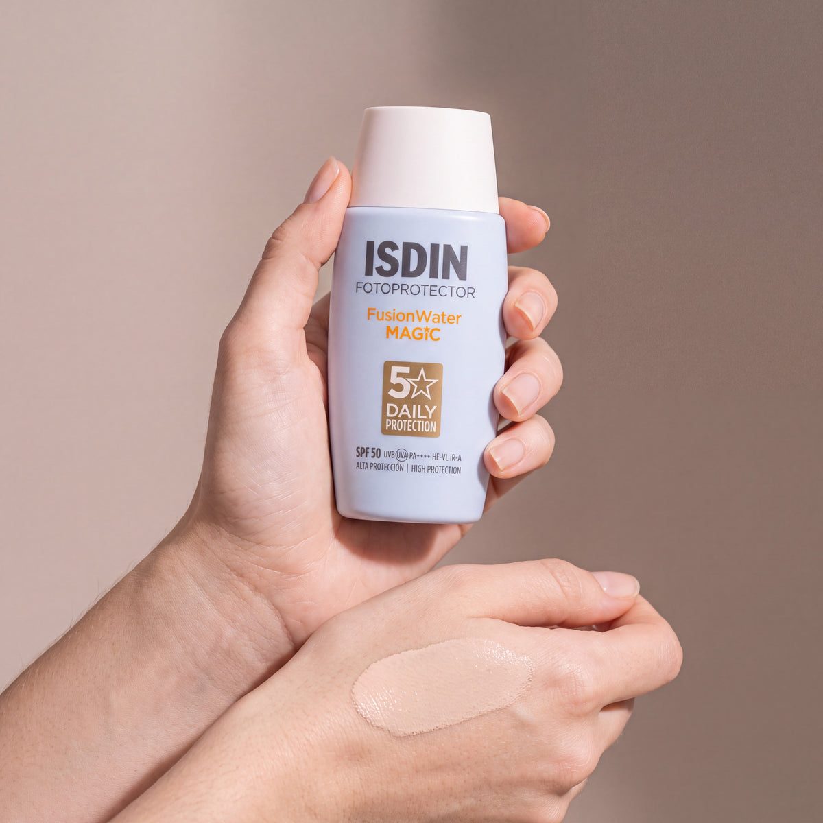 ISDIN Fotoprotector Fusion Water MAGIC SPF 50 held in hands, editorial studio shot