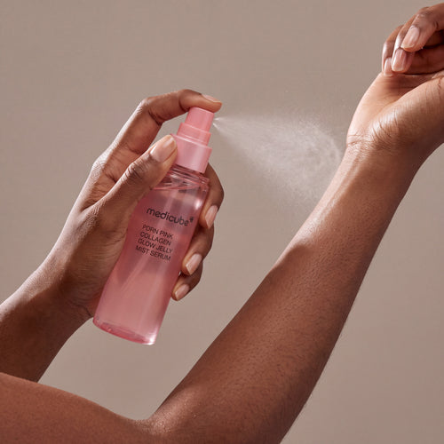 Medicube PDRN Pink Collagen Glow Jelly Mist Serum held in hands, editorial studio shot