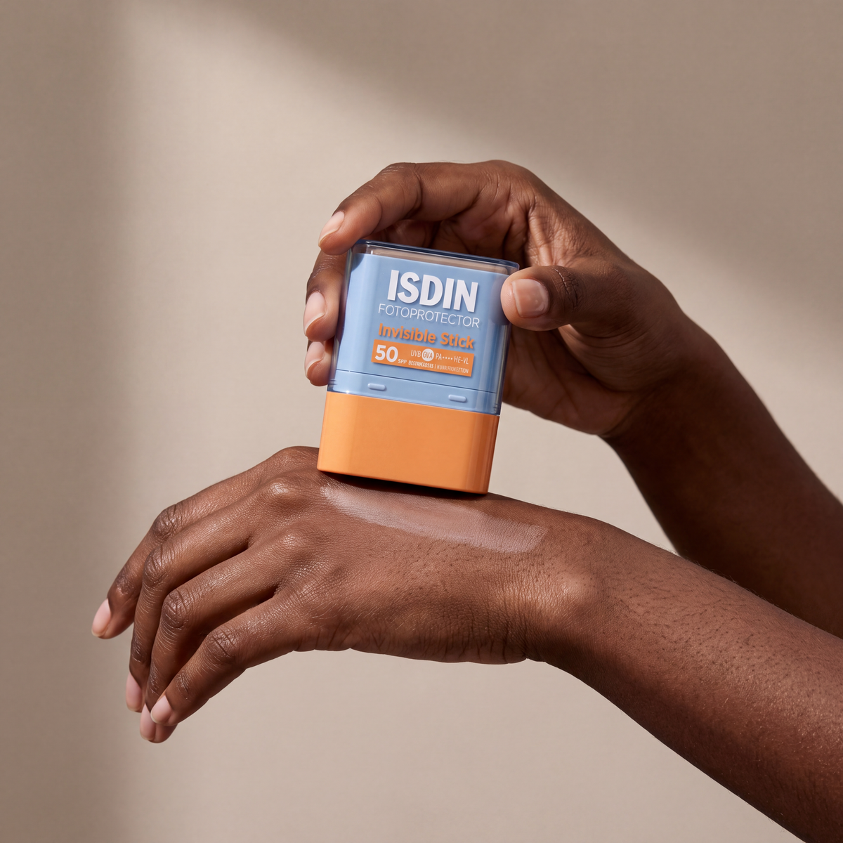 ISDIN Fotoprotector Invisible Stick SPF 50 held in hands, editorial studio shot
