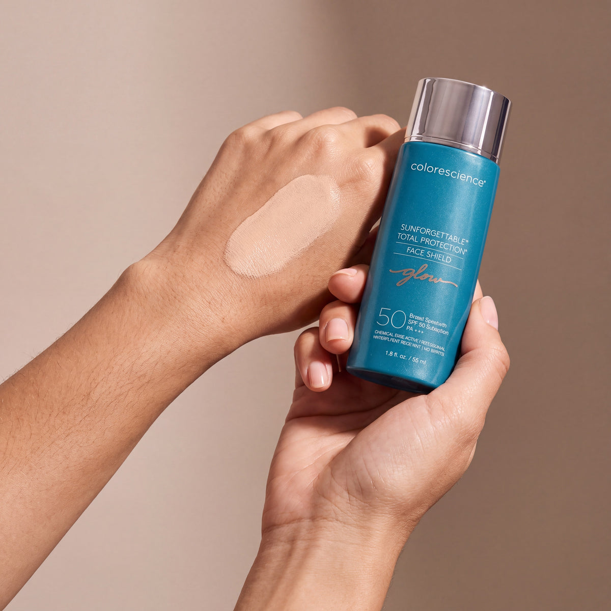 Colorescience Sunforgettable Total Protection Face Shield Glow SPF 50 held in hands, editorial studio shot