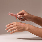 Colorescience Peptide Lip Shine SPF 30 – Champagne held in hands, editorial studio shot