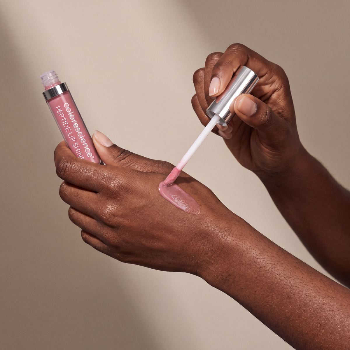 Colorescience Peptide Lip Shine SPF 30 – Rose held in hands, editorial studio shot