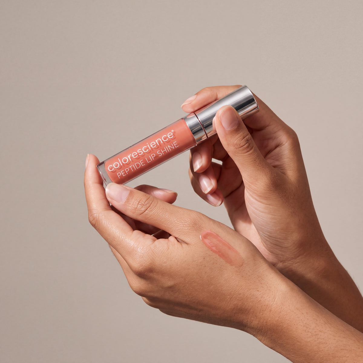 Colorescience Peptide Lip Shine SPF 30 – Savanna held in hands, editorial studio shot