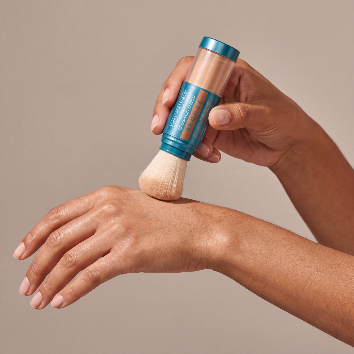 Colorescience Sunforgettable® Total Protection™ Brush-On Shield SPF 50 – Bronze held in hands, editorial studio shot
