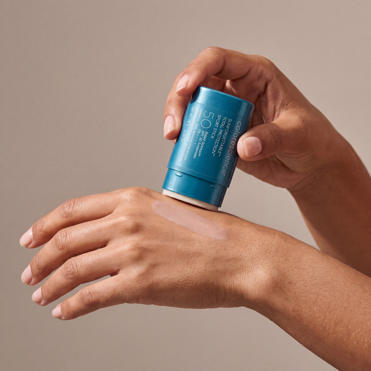 Colorescience Sport SPF Stick held in hands, editorial studio shot