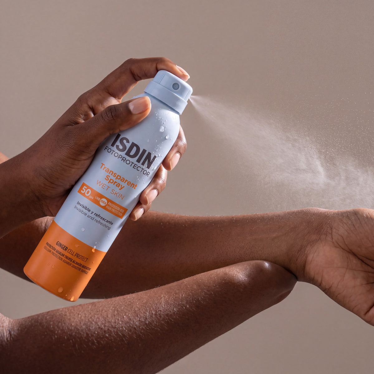 Isdin Transparent Spray held in hands, editorial studio shot