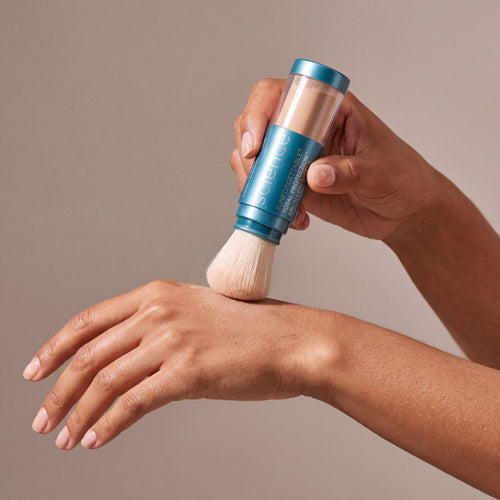 Colorescience Brush-On Shield SPF Sheer Medium held in hands, editorial studio shot