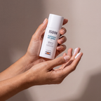 Isdin Eryfotona SPF 99 held in hands, editorial studio shot