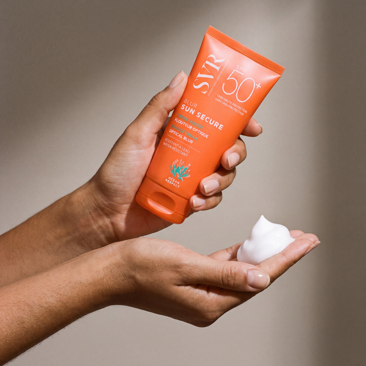 SVR Sun Secure SPF Mousse held in hands, editorial studio shot