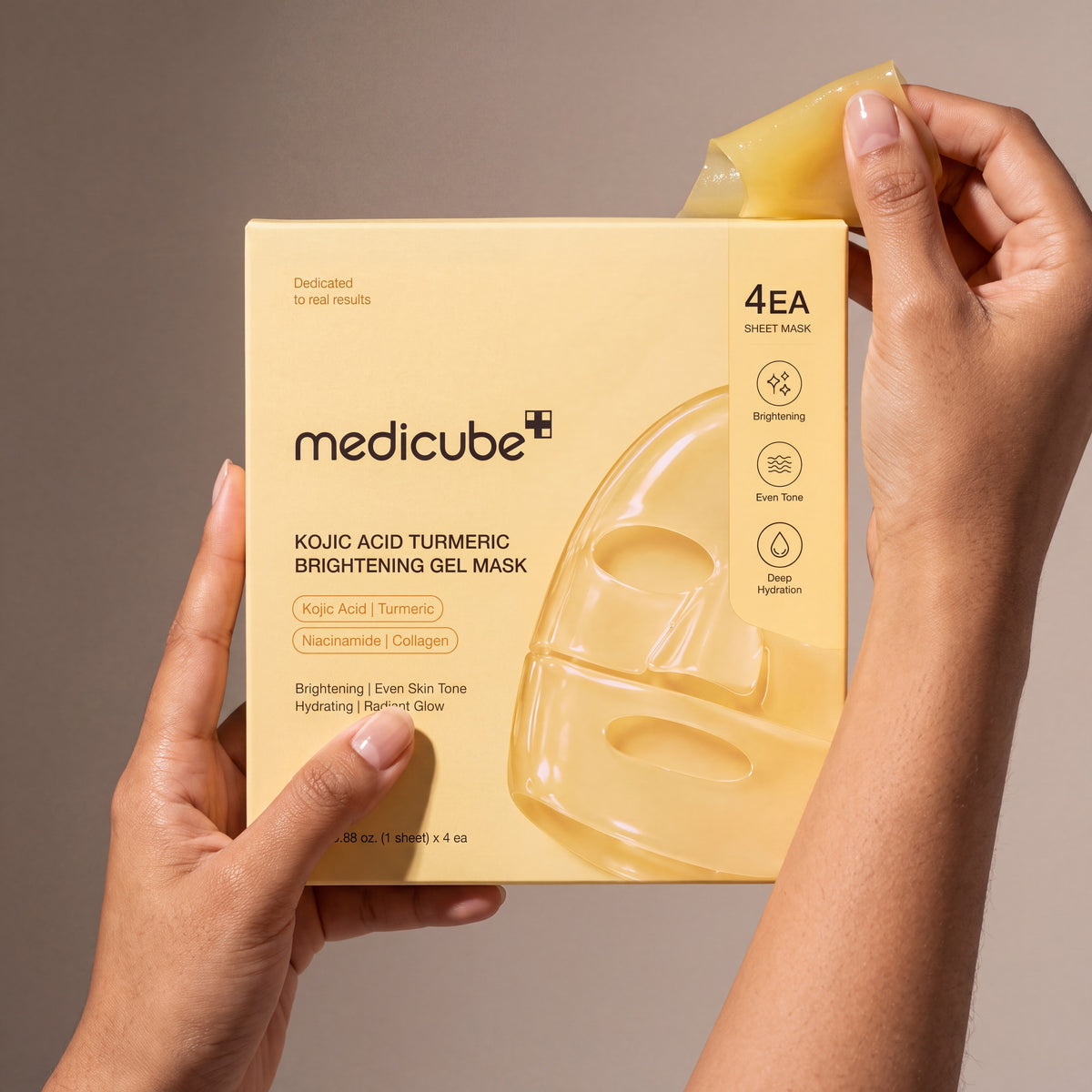 Medicube Kojic Acid Turmeric Brightening Gel Mask held in hands, editorial studio shot