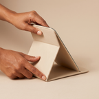 Portable PU Leather Foldable Makeup Mirror held in hands, editorial studio shot