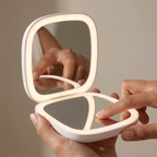 USB Touch Sensor LED Makeup Mirror in hands, editorial studio shot